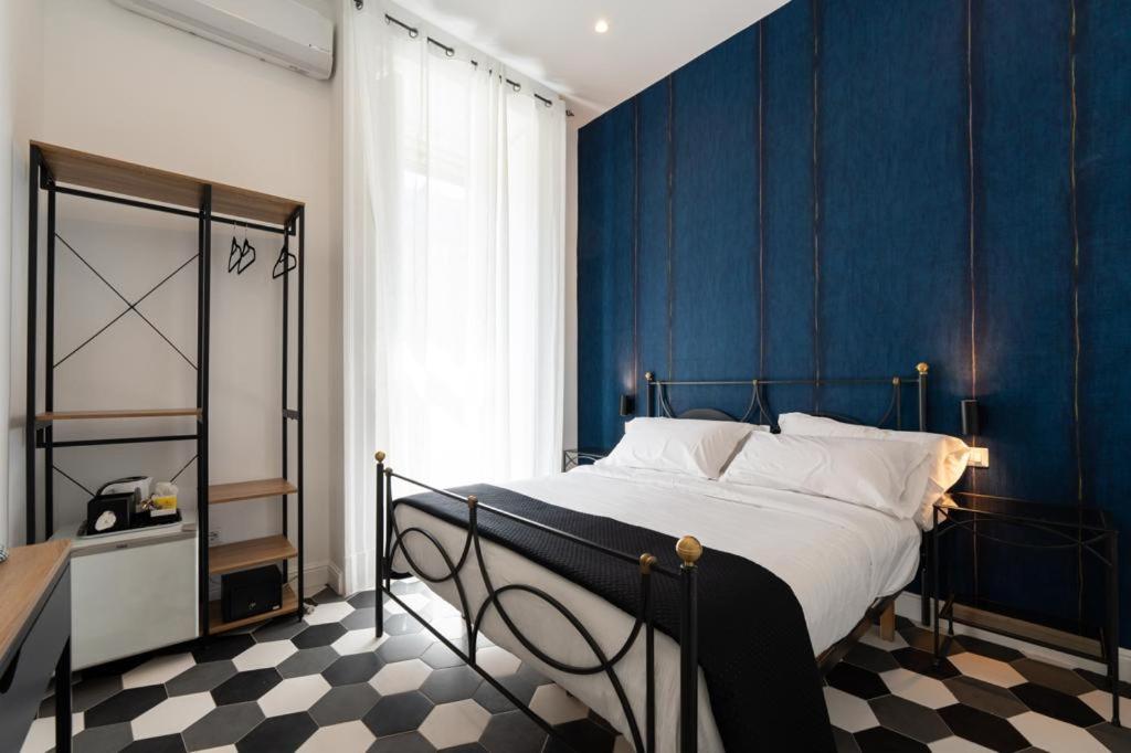 um quarto com uma cama com paredes azuis e um piso em xadrez em Al 4 Piano em Nápoles