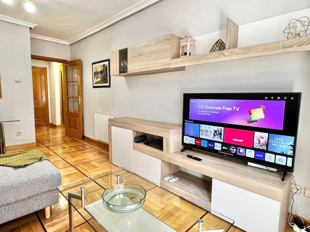 uma sala de estar com uma grande televisão de ecrã plano em LG Apartamento exclusivo de lujo em Madri