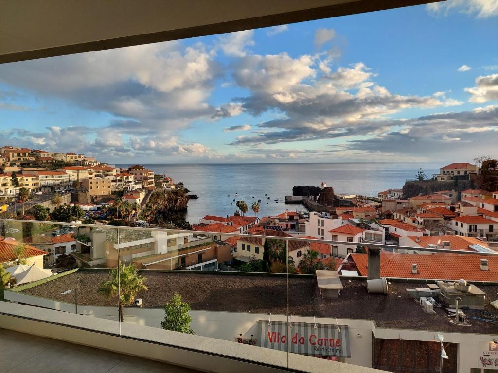 een uitzicht op de stad en de oceaan vanuit een gebouw bij Stunning Lobos View in Câmara de Lobos