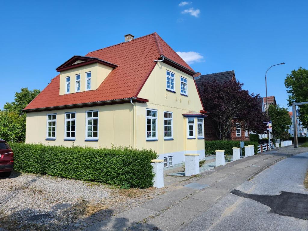 ein gelbes Haus mit rotem Dach auf einer Straße in der Unterkunft City Breakaway in Sønderborg