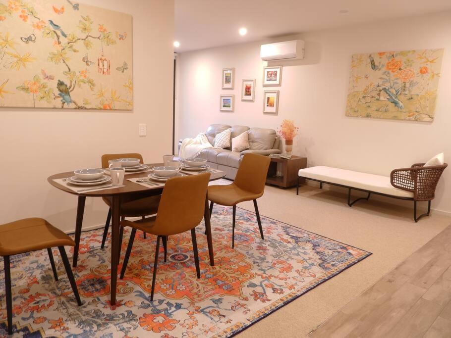 uma sala de estar com uma mesa e cadeiras e um sofá em Caulfield Village Apartment em Melbourne