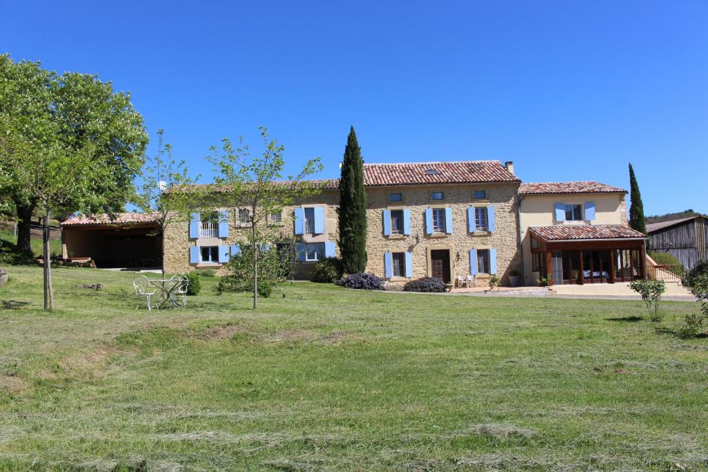 ein großes Haus mit einem Hof davor in der Unterkunft Gites et Roulottes au Domaine de la Trille in Sainte-Foi