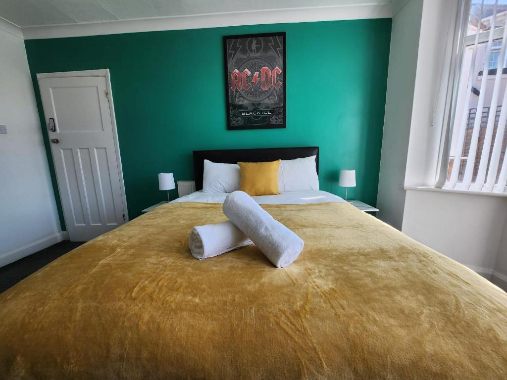 a bedroom with a large bed with a green wall at Solihull Shared House in Birmingham