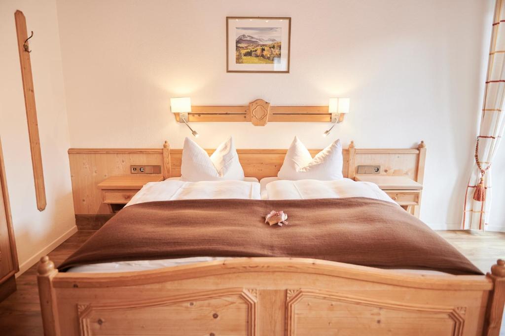 Un dormitorio con una gran cama de madera con almohadas blancas. en Haus Ranker, en Reit im Winkl