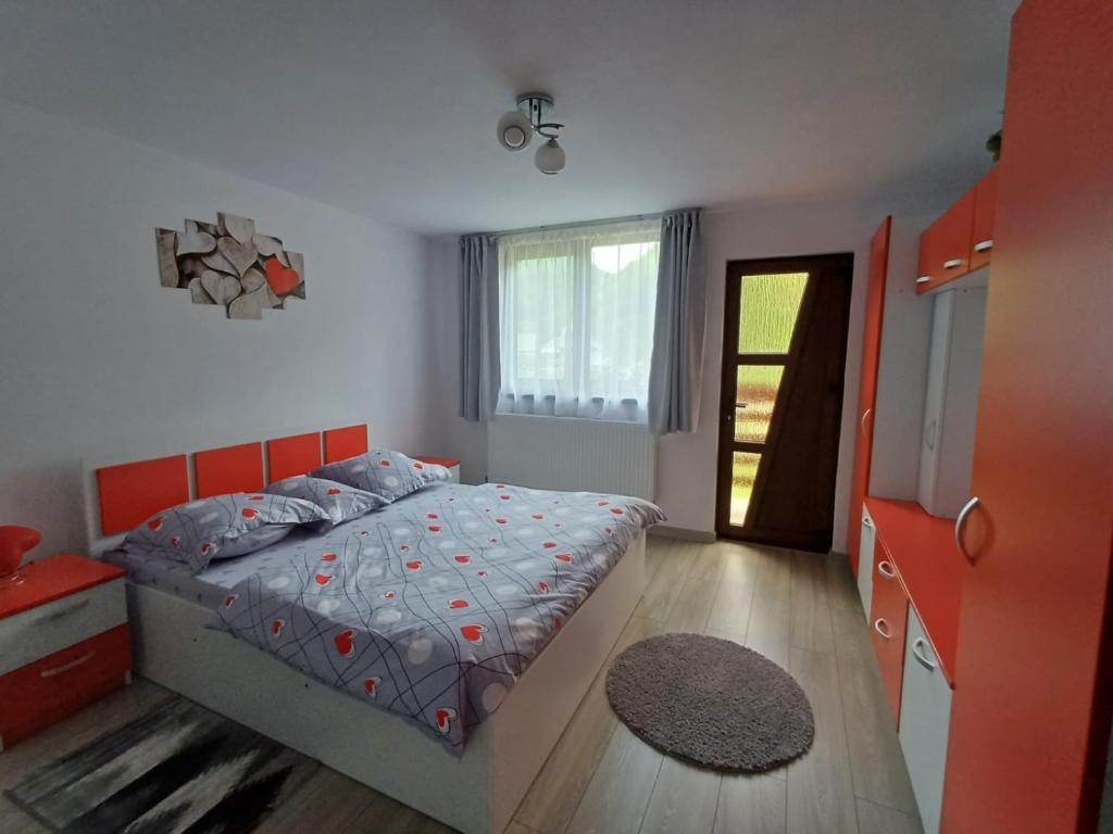 a bedroom with a bed with an orange headboard at Cabana Acasă la Delia in Gîrda de Sus