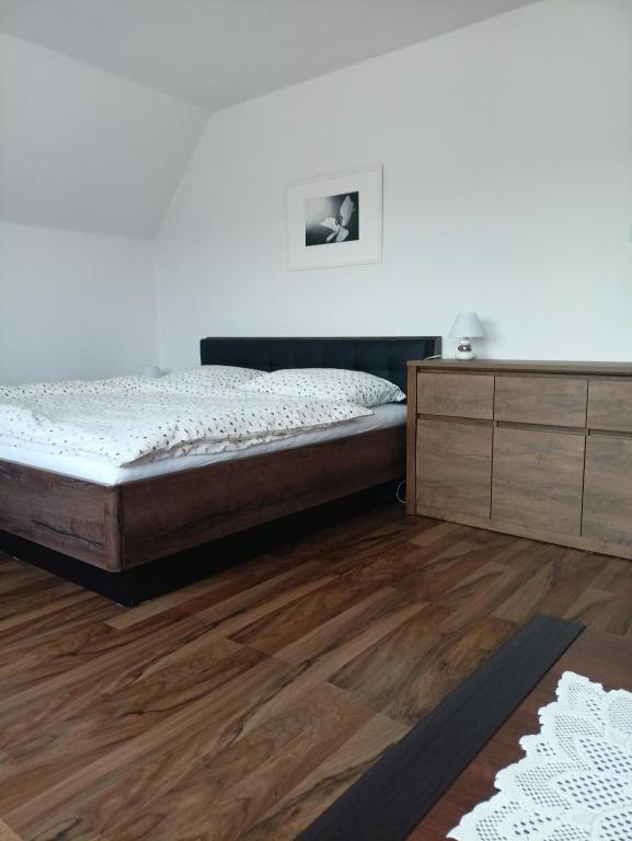 1 dormitorio con 1 cama y suelo de madera en Ubytovani Trojakova, en Český Krumlov