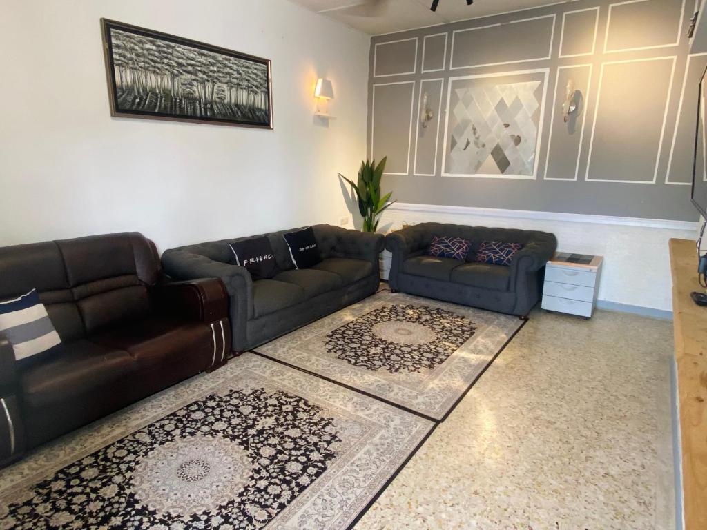uma sala de estar com um sofá de couro e um tapete em MARIDA HOMESTAY MusIim Only em Seremban