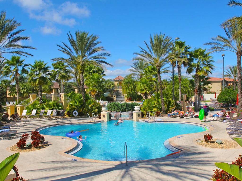 a swimming pool at a resort with palm trees at Regal Palms Lovely 3 Br Sleeps 8mins To Disney in Davenport
