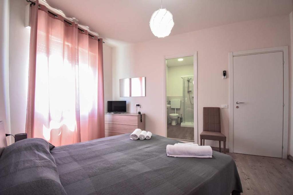 una camera da letto con un grande letto con due asciugamani di hotel La pineta a Carrara