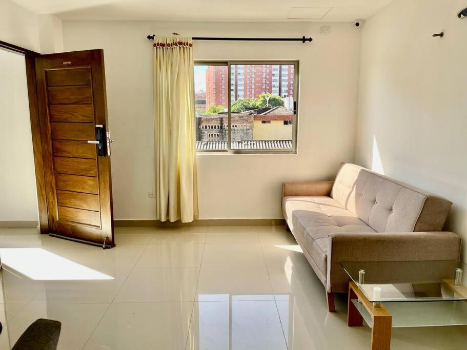 ein Wohnzimmer mit einem Sofa und einem Fenster in der Unterkunft Hermoso apartamento en el corazon del carnaval in Barranquilla