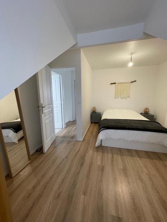 1 dormitorio con 1 cama y suelo de madera en La Casita d’Ana, en Viry-Châtillon