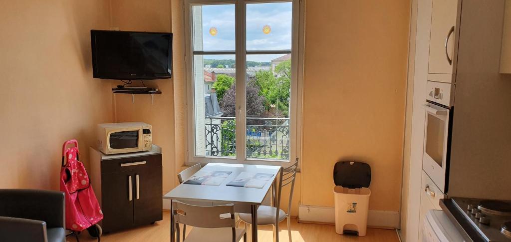 Habitación pequeña con mesa y ventana en Le Continental, en Vittel