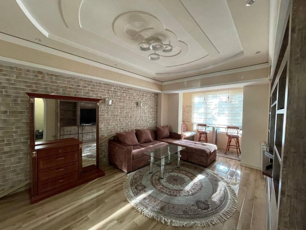 uma sala de estar com um sofá e uma mesa em 1 Bedroom stylish apartment in TSUM em Tashkent