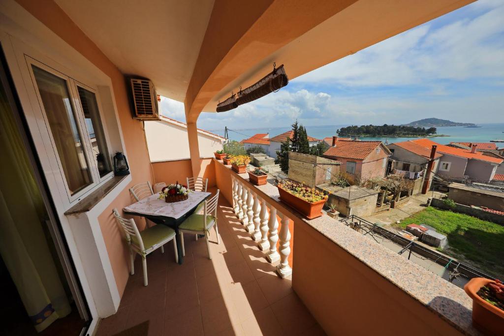a balcony with a table and a view of the ocean at Sabina More in Preko