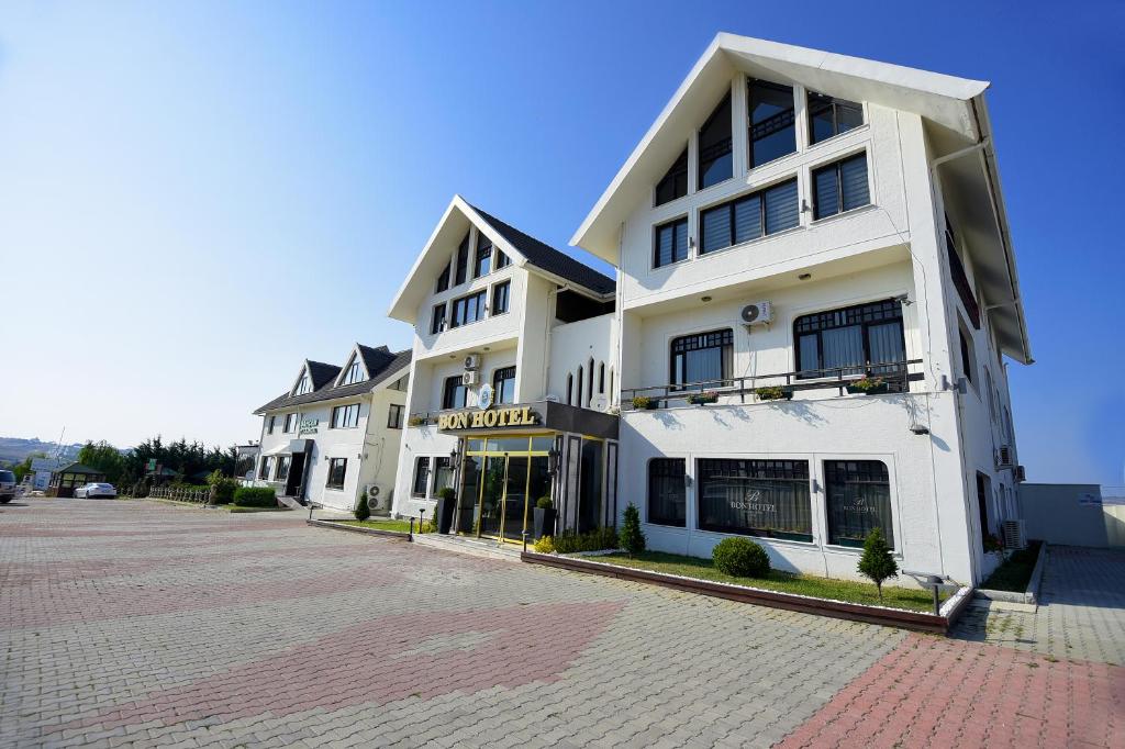 a large white building on a brick street at Hotel Bon Garden City in Silivri