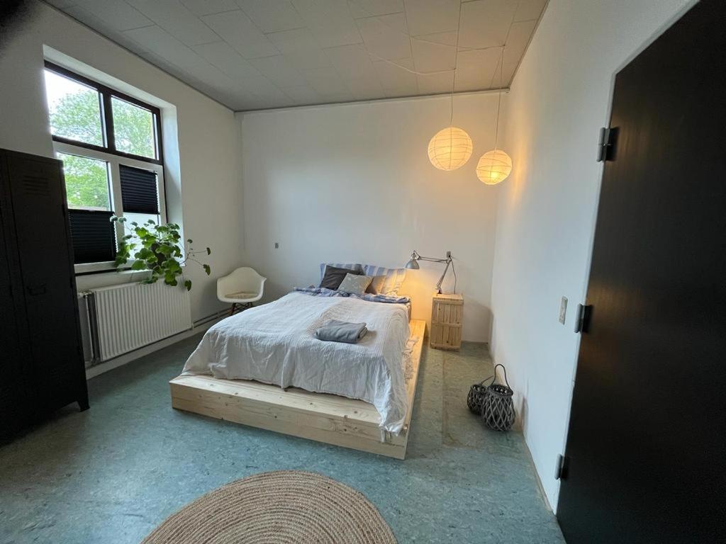 een witte slaapkamer met een bed en een raam bij Room 7 - Hawkraft kulturhotel in Vestervig