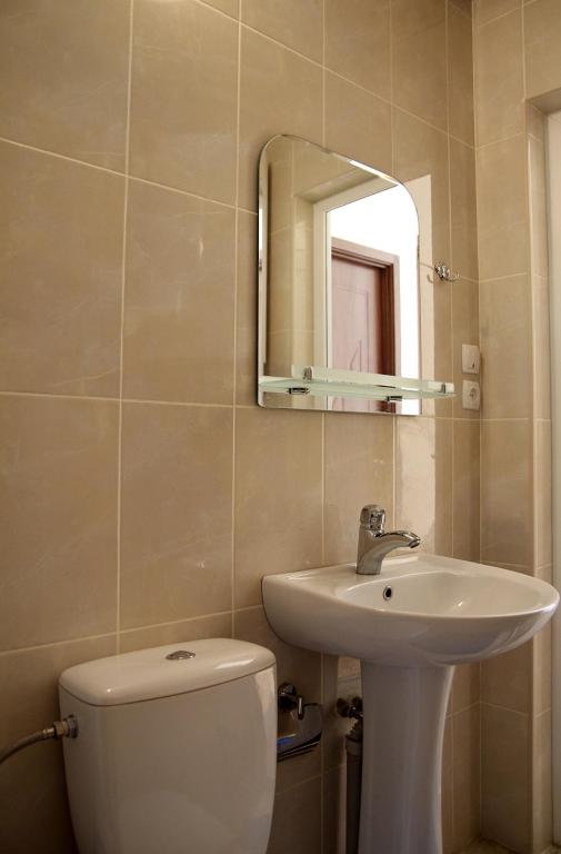 un bagno con un water, un lavandino e uno specchio di Guesthouse Lenjeri a Mestia