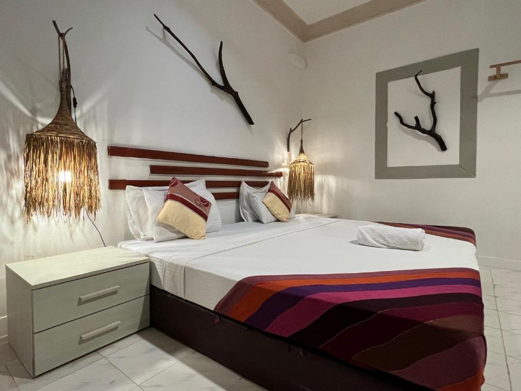 a bedroom with a large bed with antlers on the wall at Ocean Cottage Maldives in Thulusdhoo