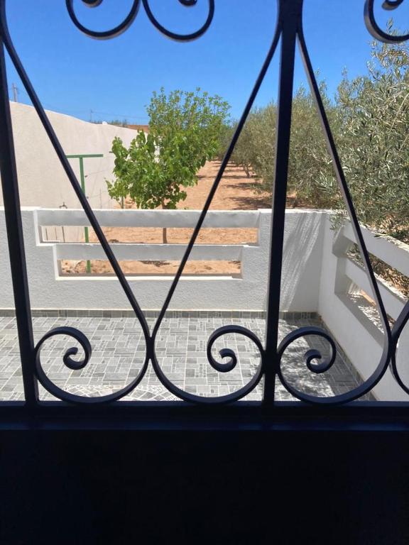 a view from a window of a porch with a bench at Appartement Djerba in El Mây