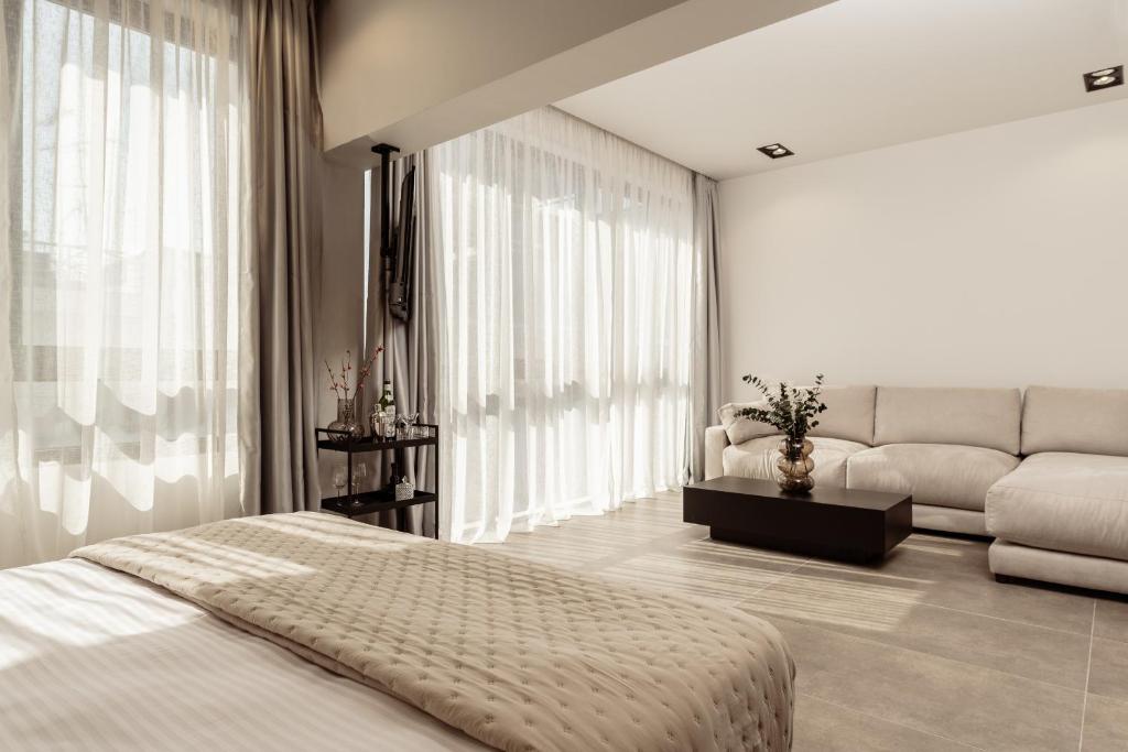 1 dormitorio con 1 cama y 1 sofá en La Maison Suites, en Zakynthos