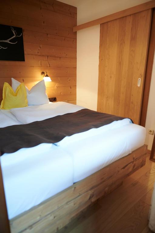 a large white bed in a room with wooden walls at Haus Sonnwies in Reit im Winkl