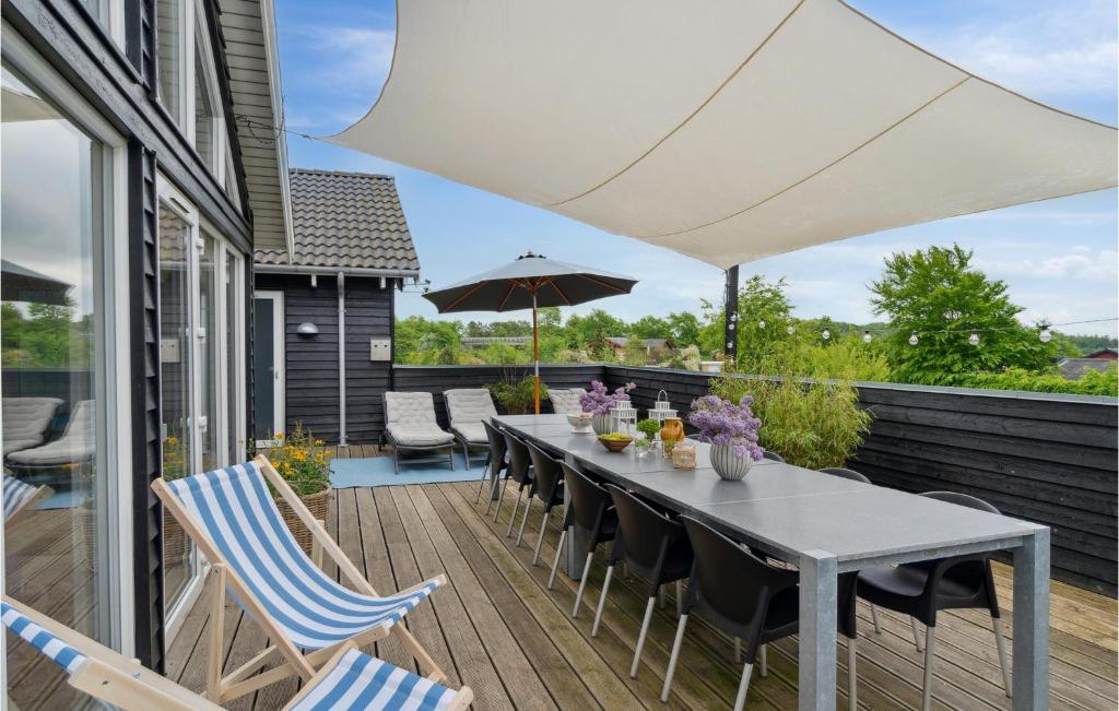 a patio with a table and chairs and an umbrella at Nice Home In Tisvildeleje With Private Swimming Pool, Can Be Inside Or Outside in Tisvildeleje