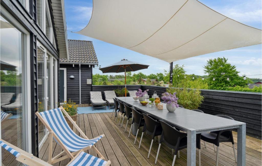 a patio with a table and chairs and an umbrella at Amazing Home In Tisvildeleje With Sauna in Tisvildeleje