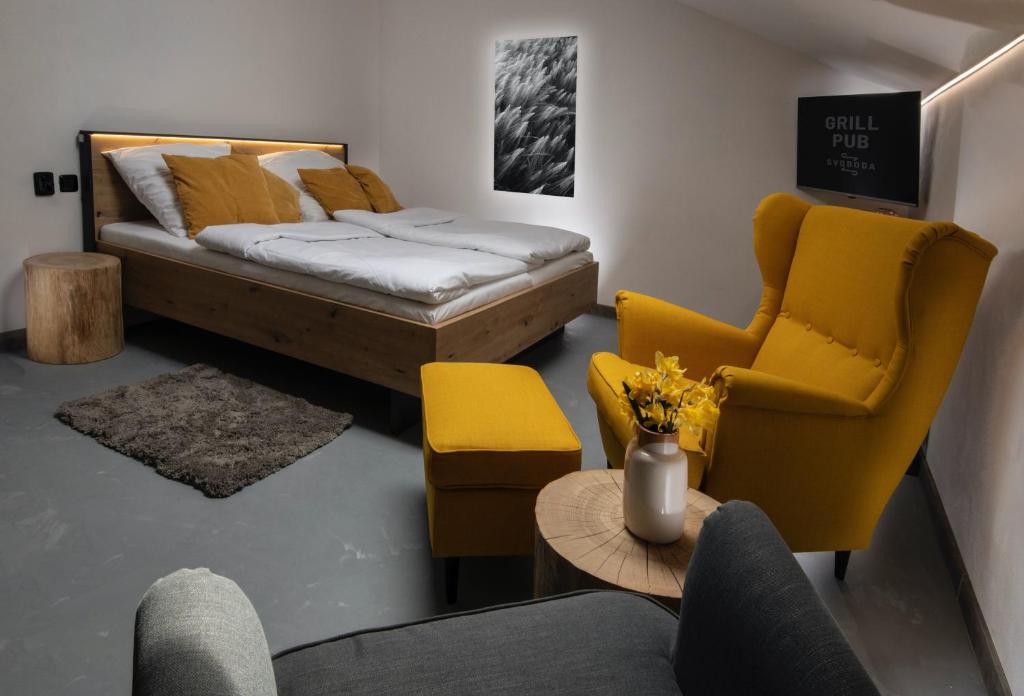 Cette chambre comprend un lit, deux chaises et une table. dans l'établissement Rooms Svoboda, à Olomouc