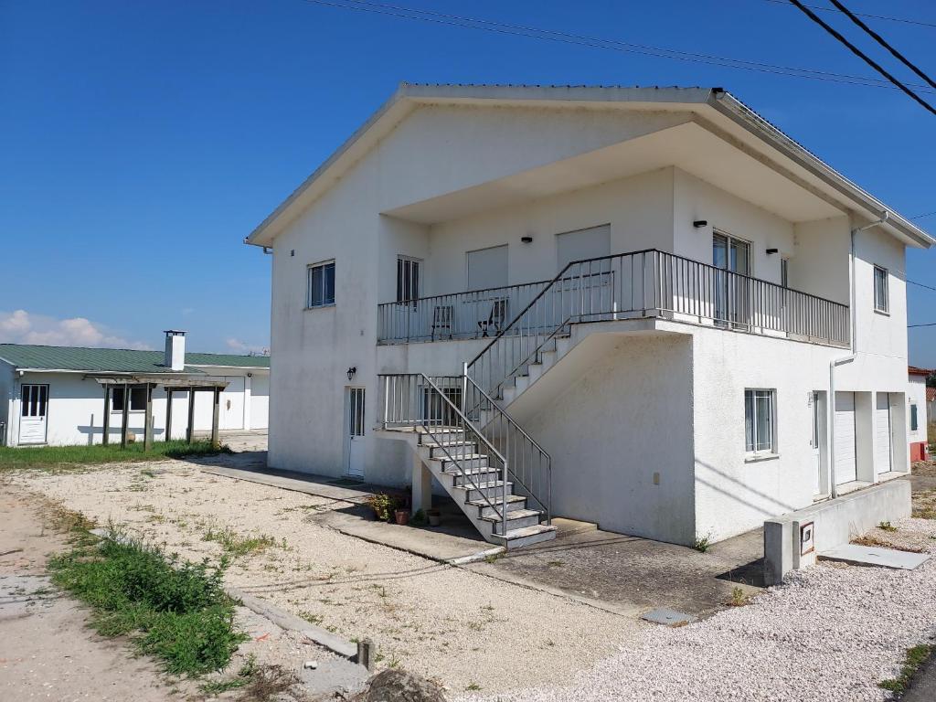 ein weißes Haus mit einer Treppe davor in der Unterkunft Casa Férias 