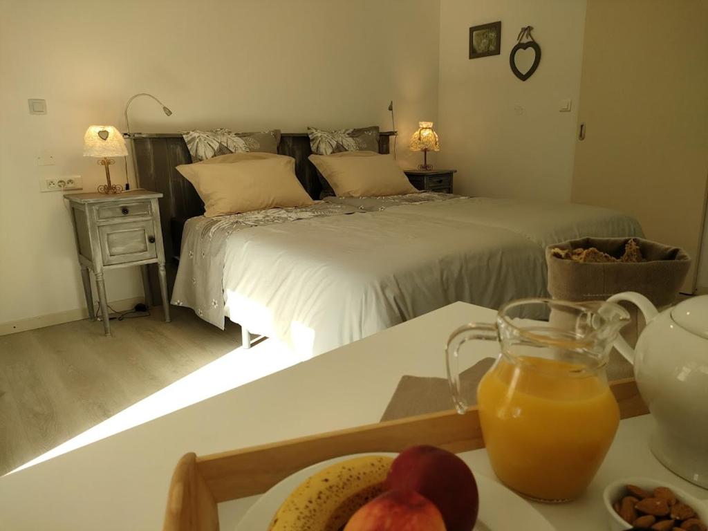 Un dormitorio con una cama y una bandeja de fruta en una mesa. en Chambre d'hôtes Tournesol, piscine en campagne gersoise, en Lias-dʼArmagnac