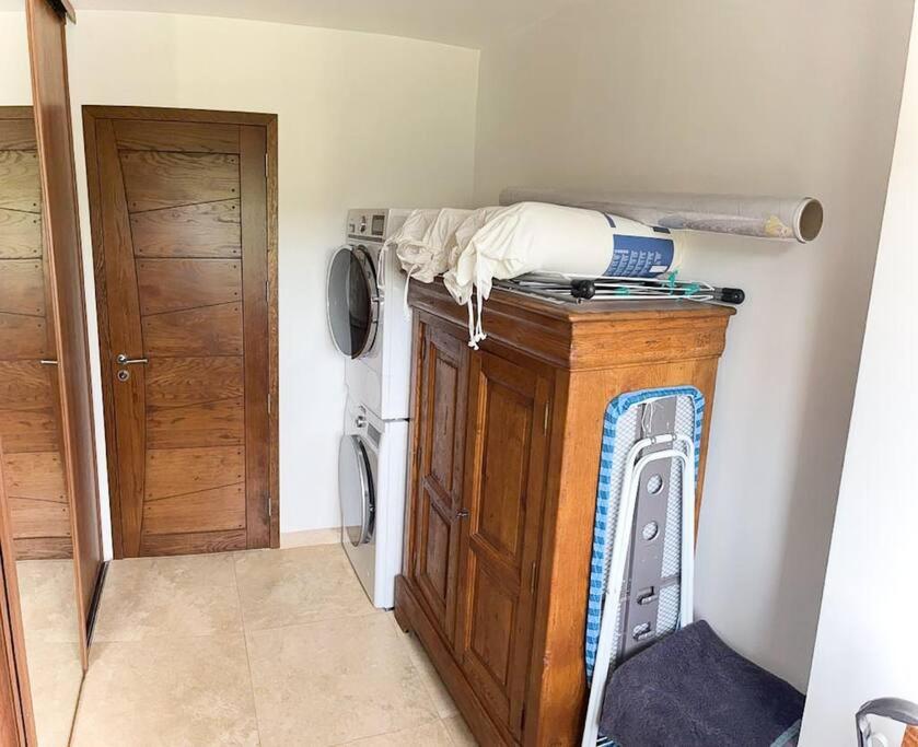 a laundry room with a washing machine and a washer at Belle villa avec jardin piscine et salle de sport in Montauroux