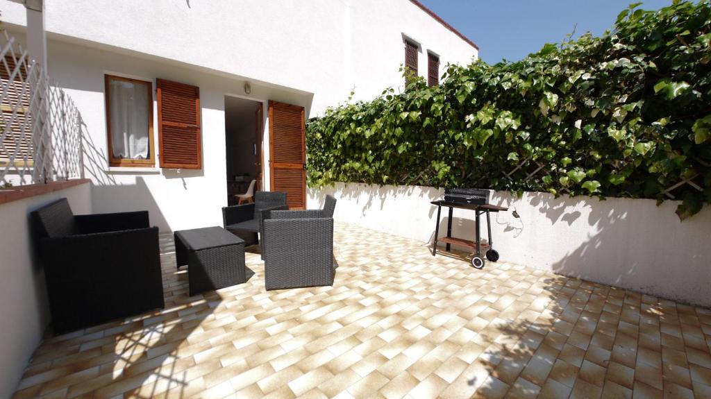 un patio con sillas y una mesa junto a un edificio en Marcelli Guest House, en Numana