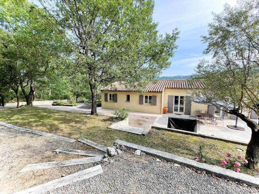 a house with a lot of trees and a yard at Belle villa avec jardin piscine et salle de sport in Montauroux