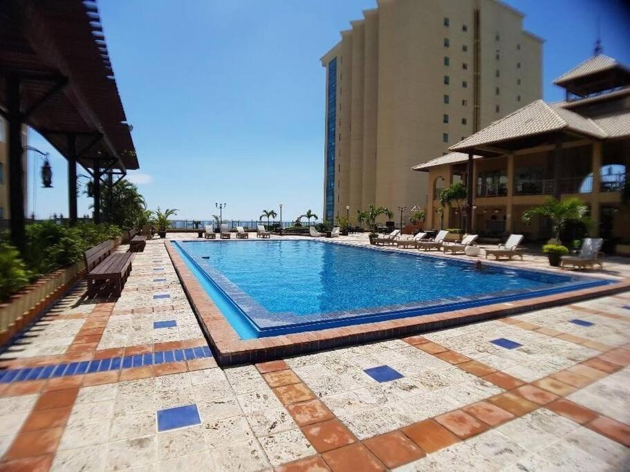 ein großer Pool mit Stühlen und ein Gebäude in der Unterkunft paradisíaco y hermoso apartamento in Santo Domingo
