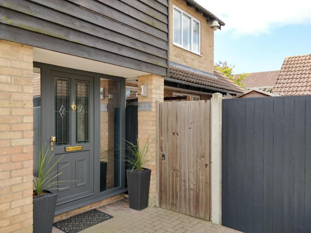 a house with a black door and a fence at 23 Brandeston Close in Sudbury
