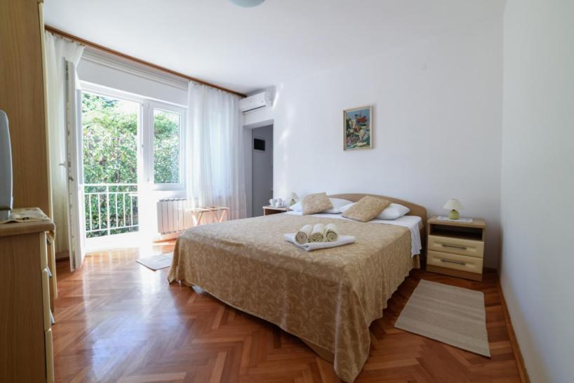 een slaapkamer met een bed en een groot raam bij Cozy Studio Near Beach in Baška