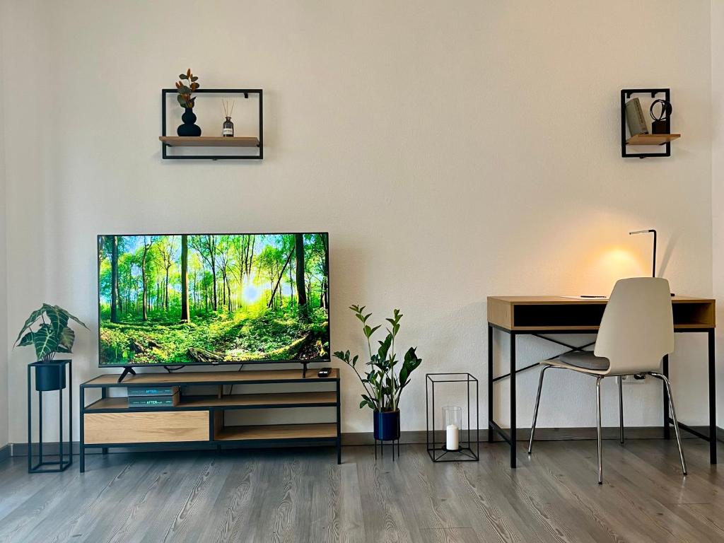 ein Wohnzimmer mit einem TV und einem Schreibtisch in der Unterkunft Ruhe & Zentral! 2-Zimmer Kaiser-CITY-Appartement mit Balkon und Smart-TV in der Kaiserstraße in Karlsruhe beim Europaplatz in Karlsruhe