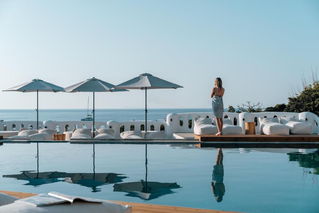 une femme debout au bord d'une piscine dans l'établissement Penelope Village, à Kalo Livadi