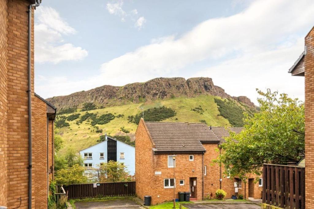 a group of houses with a mountain in the background at Entire City Center Cozy Flat in Edinburgh