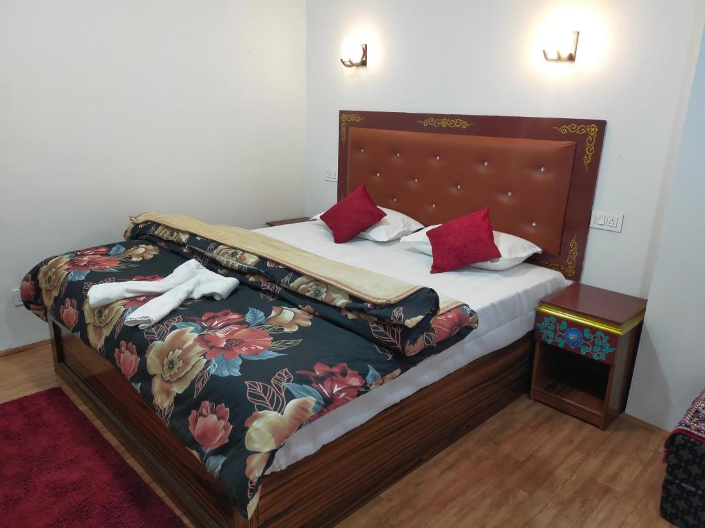 um quarto com uma cama com colcha floral em Sikkimese Inn em Ravangla