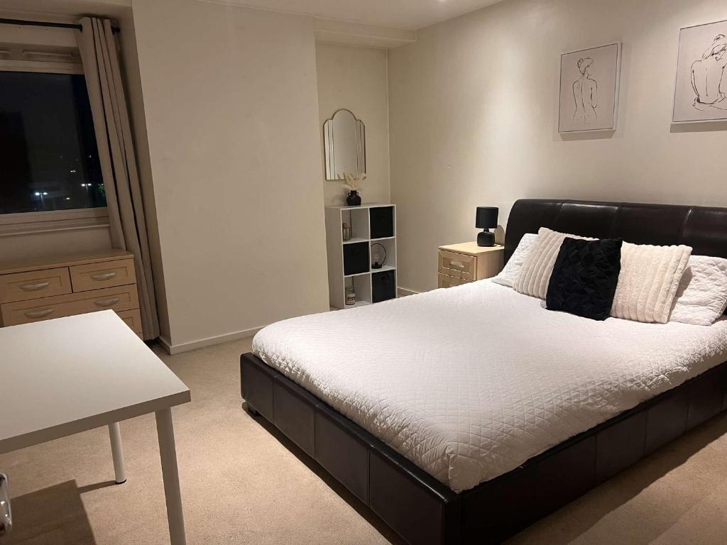 a bedroom with a large bed and a television at 2 bedroom luxury apartment Birmingham city centre in Birmingham