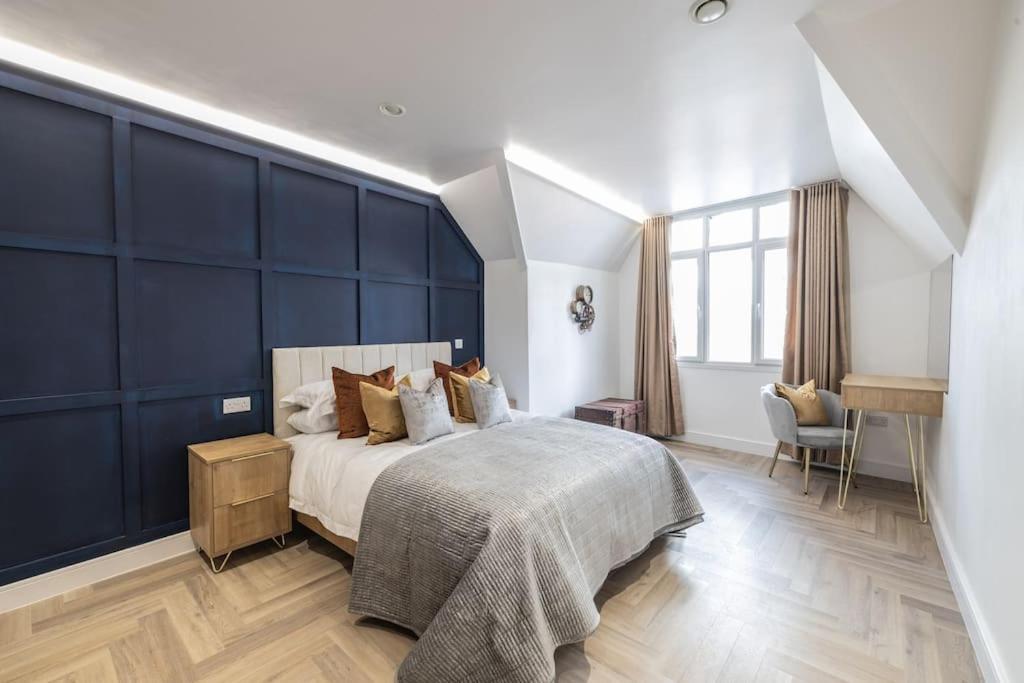 萊斯特的住宿－The Pocklington - The Magistrates Suite，一间卧室设有一张蓝色墙壁的大床
