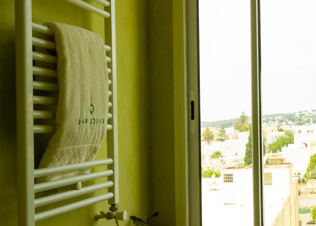 a bathroom with a towel hanging on a window at Dar Souad in La Marsa