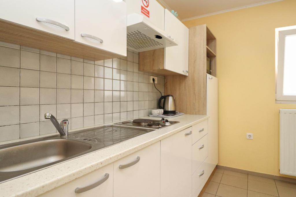 a kitchen with white cabinets and a sink at Beg Rooms in Maribor