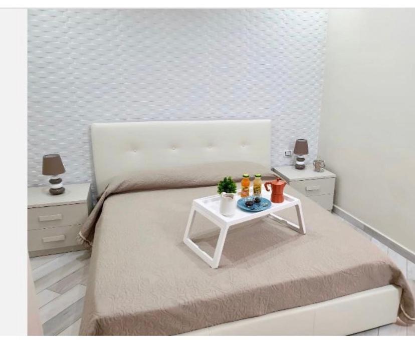 - une chambre avec un lit blanc et une table blanche dans l'établissement B & B VIA ROMA, à Ercolano