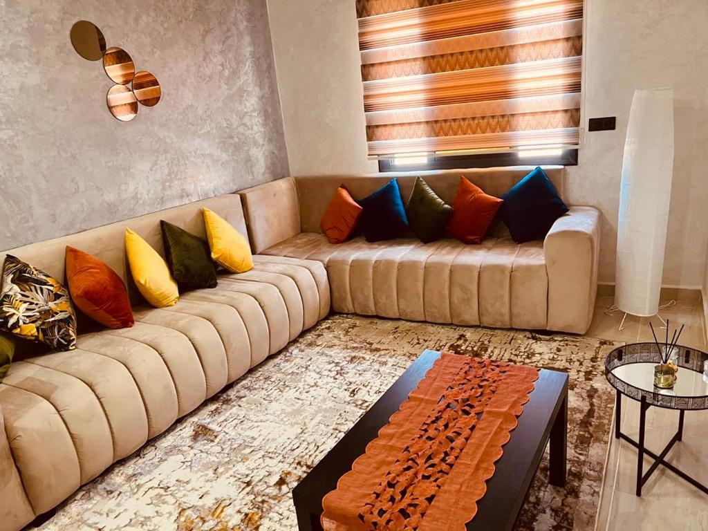 a living room with a couch with colorful pillows at Appartement INES Saidia in Saidia 