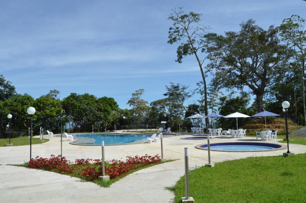 - une piscine avec des tables et des parasols dans un parc dans l'établissement Hotel Mirador de la Esperanza, à San Juan de Rioseco 