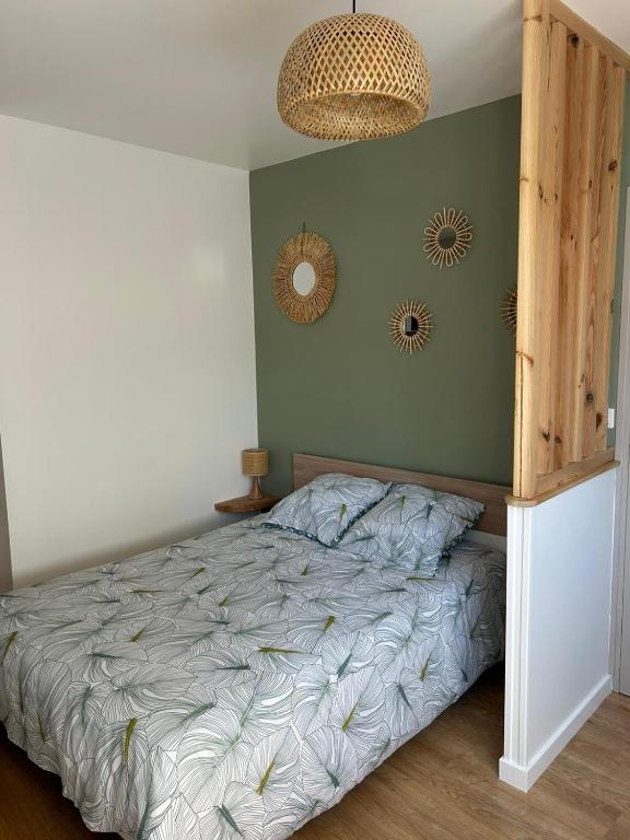 une chambre avec un lit et deux miroirs au mur dans l'établissement Les voiles, à Dieppe