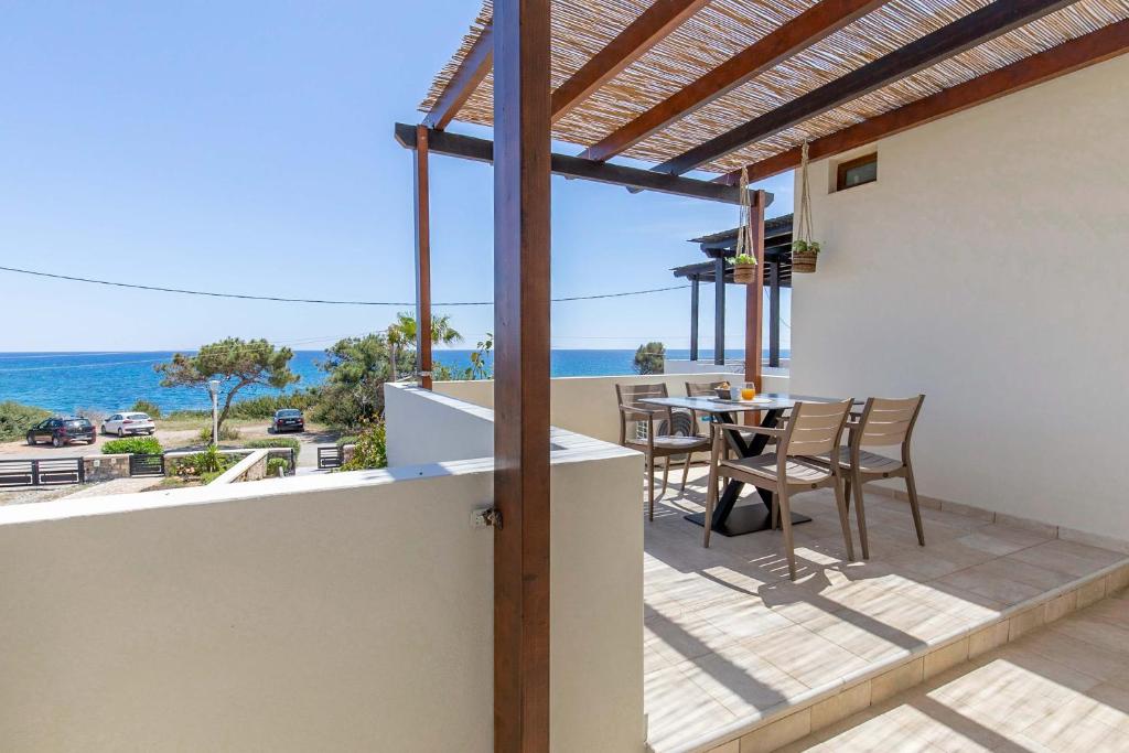 a balcony of a house with a table and chairs at Villa Sunrise in Kiotari