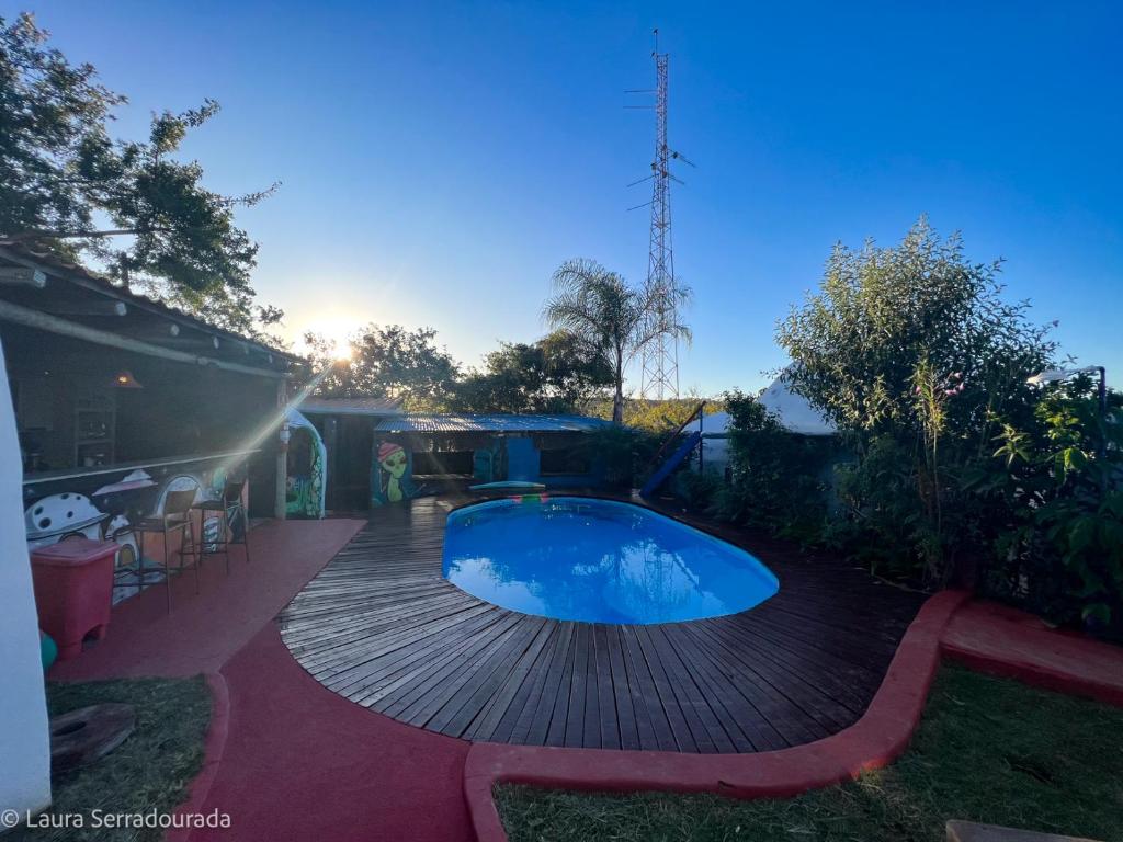 a swimming pool on a wooden deck next to a house at Pousada Espaço Naves LunaZen in Alto Paraíso de Goiás